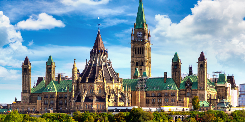 Les édifices du Parlement canadien à Ottawa, avec leurs toits en cuivre vert, leur architecture gothique et leur haute tour centrale surmontée du drapeau canadien.